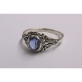 A BEAUTIFULLY DETAILED SOLID STERLING SILVER RING SET WITH A MARVELOUS FACETED BLUE STONE