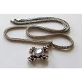 A STRONG AND STURDY "WEAVED" STERLING SILVER NECKLACE WITH A FACETED PURPLE STONE SET SILVER CROSS