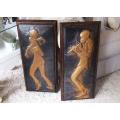 Two musical motif beaten copper wall plaques on wood backings with makers signature
