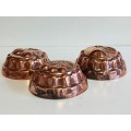 THREE VINTAGE COPPER JELLY MOULDS WITH A FRUIT MOTIF