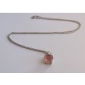 A STERLING SILVER NECKLACE WITH A FACETED PINK STONE SET STERLING SILVER PENDANT