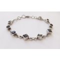 AN EYE CATCHING SOLID STERLING SILVER BRACELET SET WITH FACETED BLUEISH PURPLISH STONES !! QUALITY !