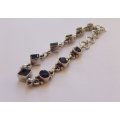 AN EYE CATCHING SOLID STERLING SILVER BRACELET SET WITH FACETED BLUEISH PURPLISH STONES !! QUALITY !