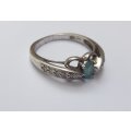 A SOLID STERLING SILVER DESIGNER STAMPED RING WITH FACETED PALE BLUE STONE - STAMPED AND TESTED