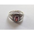 A STYLISH SOLID STERLING SILVER RING SET WITH A FACETED RED STONE !! STAMPED AND TESTED !!