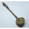 AN ANTIQUE BRASS SPOON WITH DICKENS TYPE CHARACTER ON A TWISTED STEM