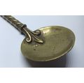 AN ANTIQUE BRASS SPOON WITH DICKENS TYPE CHARACTER ON A TWISTED STEM