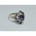 A genuine sterling silver ring with floral design and faceted purple inset - Brand new