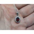A genuine sterling silver necklace and pendant with faceted red and clear insets - Brand new - Boxed