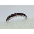 A vintage hallmarked silver eternity ring with faceted red insets - looks like garnets - tested