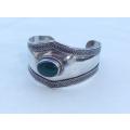A solid sterling silver cuff bangle with a green cabochon inset - stamped & tested