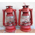 Two Red Parafin Lamps. 23cm high. As per photo