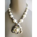 Costume Jewelry. Faux pear bead and silver color necklace with large ornate pendant. 44cm