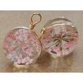Gold tone fashion necklace with unusual round glass pendant with pink dried flower inside
