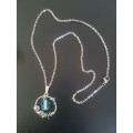Silver tone fashion necklace with sea inspired pendant The pendant has a dolphin, sea shells & a pre