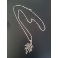 Silver tone fashion necklace with palm leaf pendant