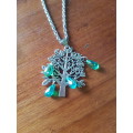 Silver tone twisted fashion necklace with the tree of life pendant The tree of life has sparkly mult