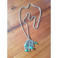 Silver tone twisted fashion necklace with the tree of life pendant The tree of life has sparkly mult