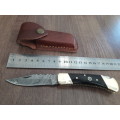 Handmade Damascus steel folding knife with Bull Horn handle scales.