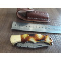 Handmade Damascus steel folding knife with Burnt Camel Bone handle scales.