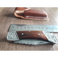 Handmade Damascus steel folding knife with Wooden handle scales.