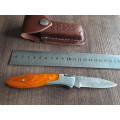 Handmade Damascus steel folding knife with Wooden handle scales.