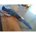 Handmade Damascus steel folding knife with MICARTA handle scales.