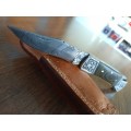 Handmade Damascus steel folding knife with MICARTA handle scales.