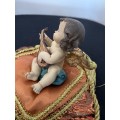 CHERUB PLAYING THE MANDOLIN SITTING ON GOLD BRAIDED CUSHION