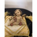 CHERUB HOLDING THE BUGLE SITTING ON GOLD BRAIDED CUSHION