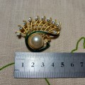 Gold-coloured vintage brooch with green inlay and diamante detail