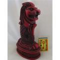 A SOLID RED RESIN PAPERWEIGHT FIGURINE OF SINGAPORE'S MYTHICAL MERLION