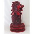 A SOLID RED RESIN PAPERWEIGHT FIGURINE OF SINGAPORE'S MYTHICAL MERLION