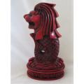 A SOLID RED RESIN PAPERWEIGHT FIGURINE OF SINGAPORE'S MYTHICAL MERLION