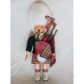 A SMALL VINTAGE SCOTTISH BAGPIPE PLAYER