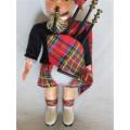A SMALL VINTAGE SCOTTISH BAGPIPE PLAYER