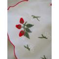 A CHEERFUL EMBROIDERED CLOTH WITH BERRIES AND SCALLOPED BORDER