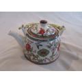 A pretty oriental teapot with floral and bird design