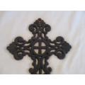 A vintage ornate wall-hanging cast iron cross