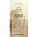 VINTAGE CUT GLASS WHISKEY DECANTER WITH A LARGE BRASS TAG & CHAIN.