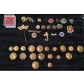A COLLECTION OF BADGES AND MILITARY UNIFORM BUTTONS SOLD AS IS