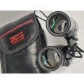 A USED TASCO POCKET BINOCUARS WITH ITS ORIGINAL COVER SOLD AS IS