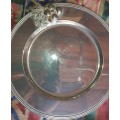 A VINTAGE ROUND  STAINLESS STEEL WITH A GRAPE VINE DESIGN ON IT SOLD AS IS