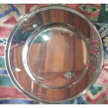 A VINTAGE ROUND  STAINLESS STEEL WITH A GRAPE VINE DESIGN ON IT SOLD AS IS