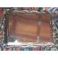 A STAINLESS STEEL RECTANGULAR WITH AN ORNATE DESIGN BORDER SERVING TRAY SOLD AS IS