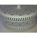 A WHITE ENAMEL PAINTED STEEL CAKE TRAY WITH AN ORNATE LID SOLD AS IS