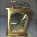 A BRONZE RYTHM TRANSSISTER ALARM CLOCK SOLD AS IS
