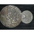 A SILVER PLATED HEAVY ROUND ENGRAVED WITH A GRAPE DESIGN CONTAINER AND A FRENCH MEDELLIAN SOLD AS IS