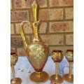 A VINTAGE GOLDPLATED  VENNETIAN STYLE ON RED GLASS DECANTER AND FIVE SHERRY GLASSES SOLD AS IS
