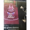 A SET OF WINE GLASS CHARMS ON A RING IN ITS ORIGINAL PACKAGING SOLD AS IS